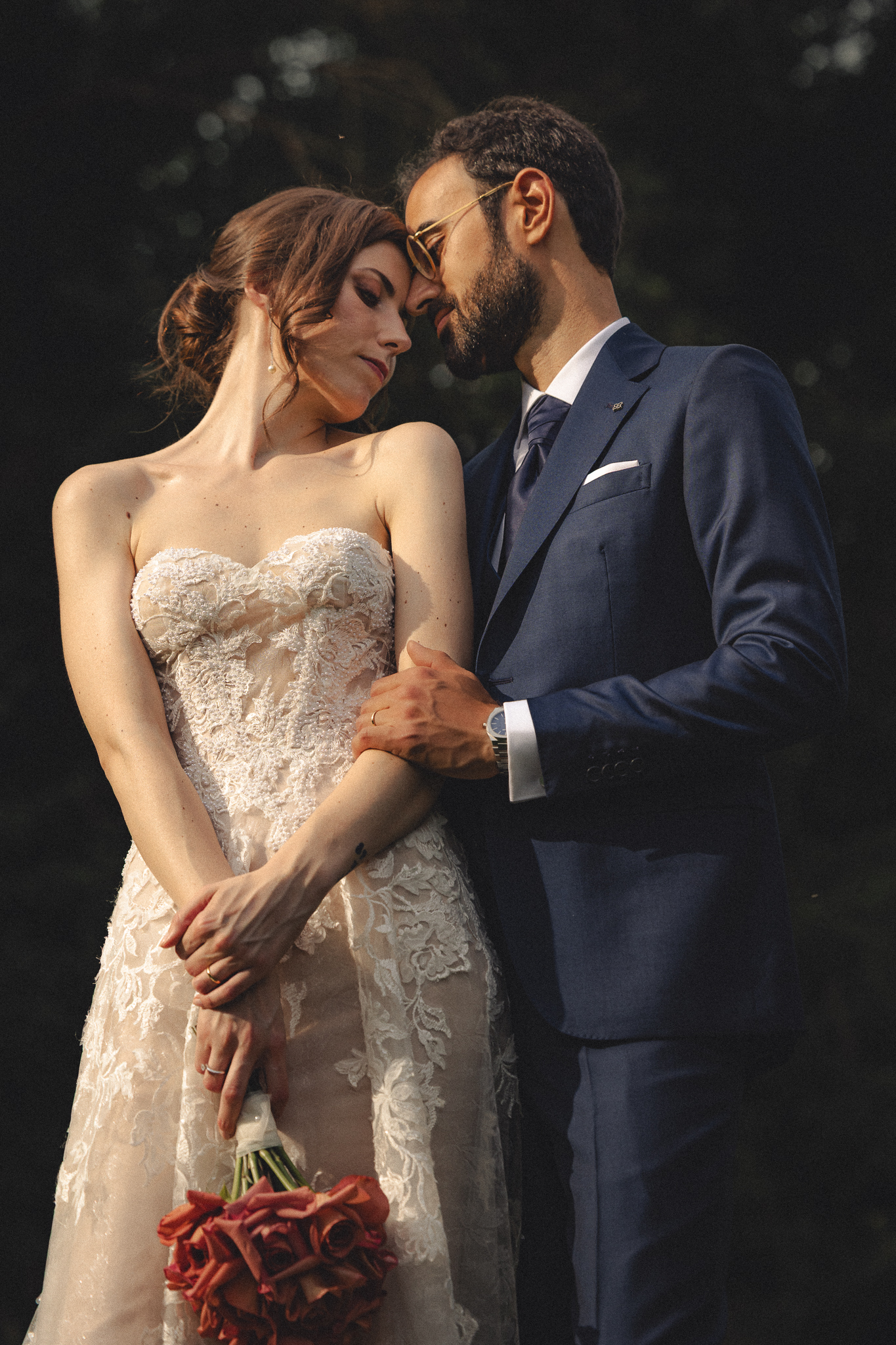 Anna appoggiata a Davide con il bouquet di rose rosse
