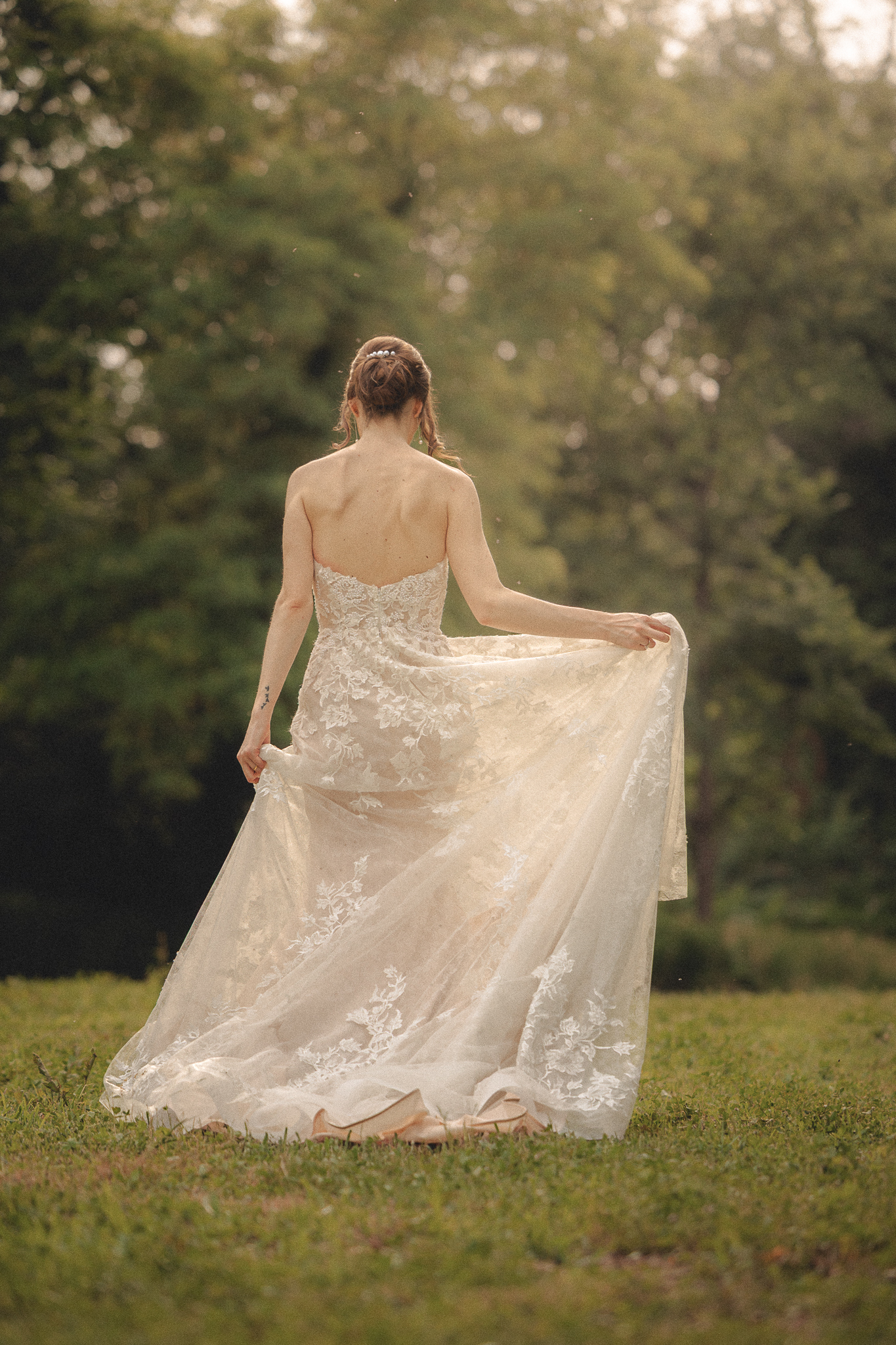 La sposa di spalle con lo strascico dell’abito in pizzo