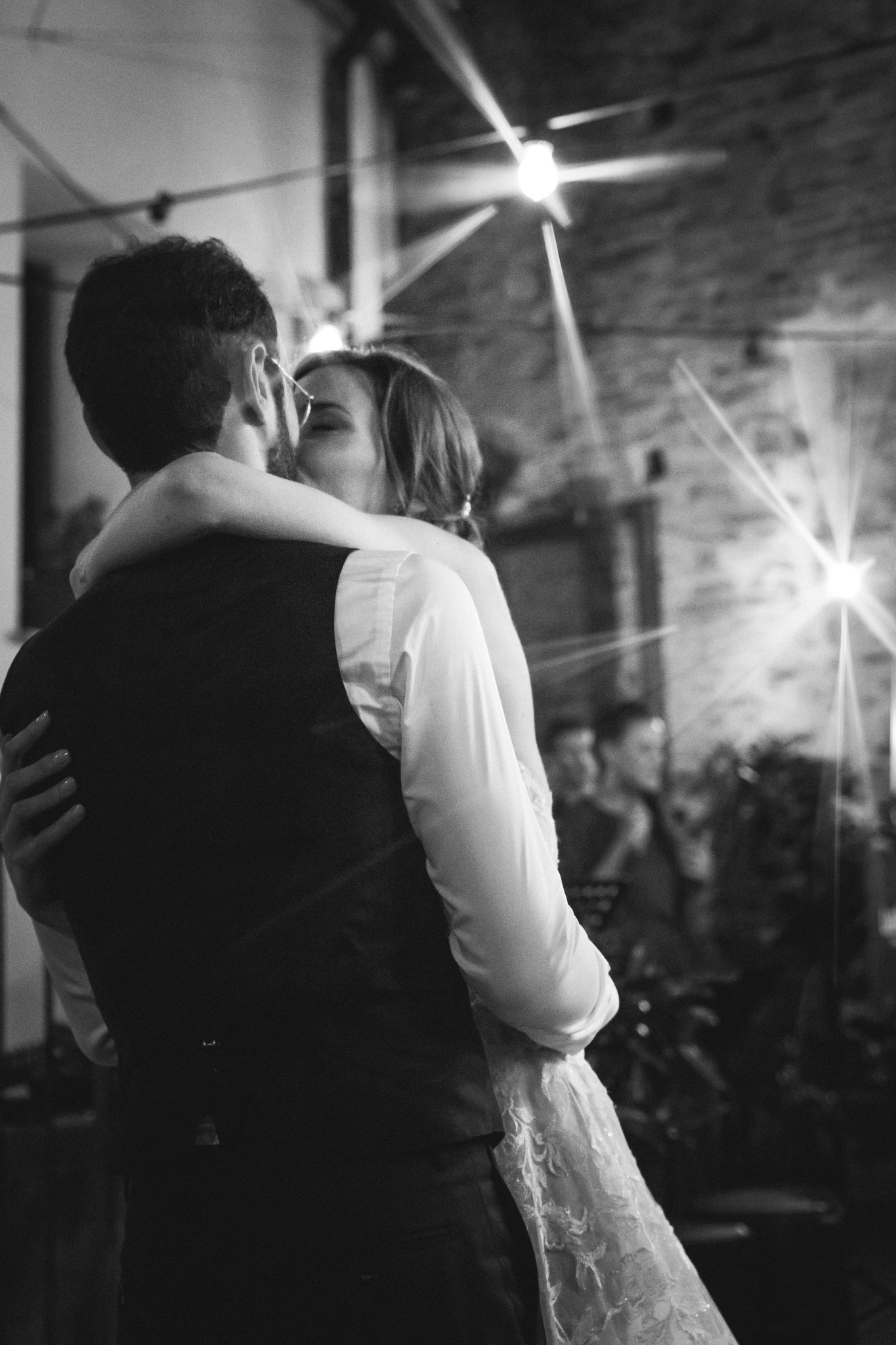 Il ballo degli sposi sotto le luci, in bianco e nero