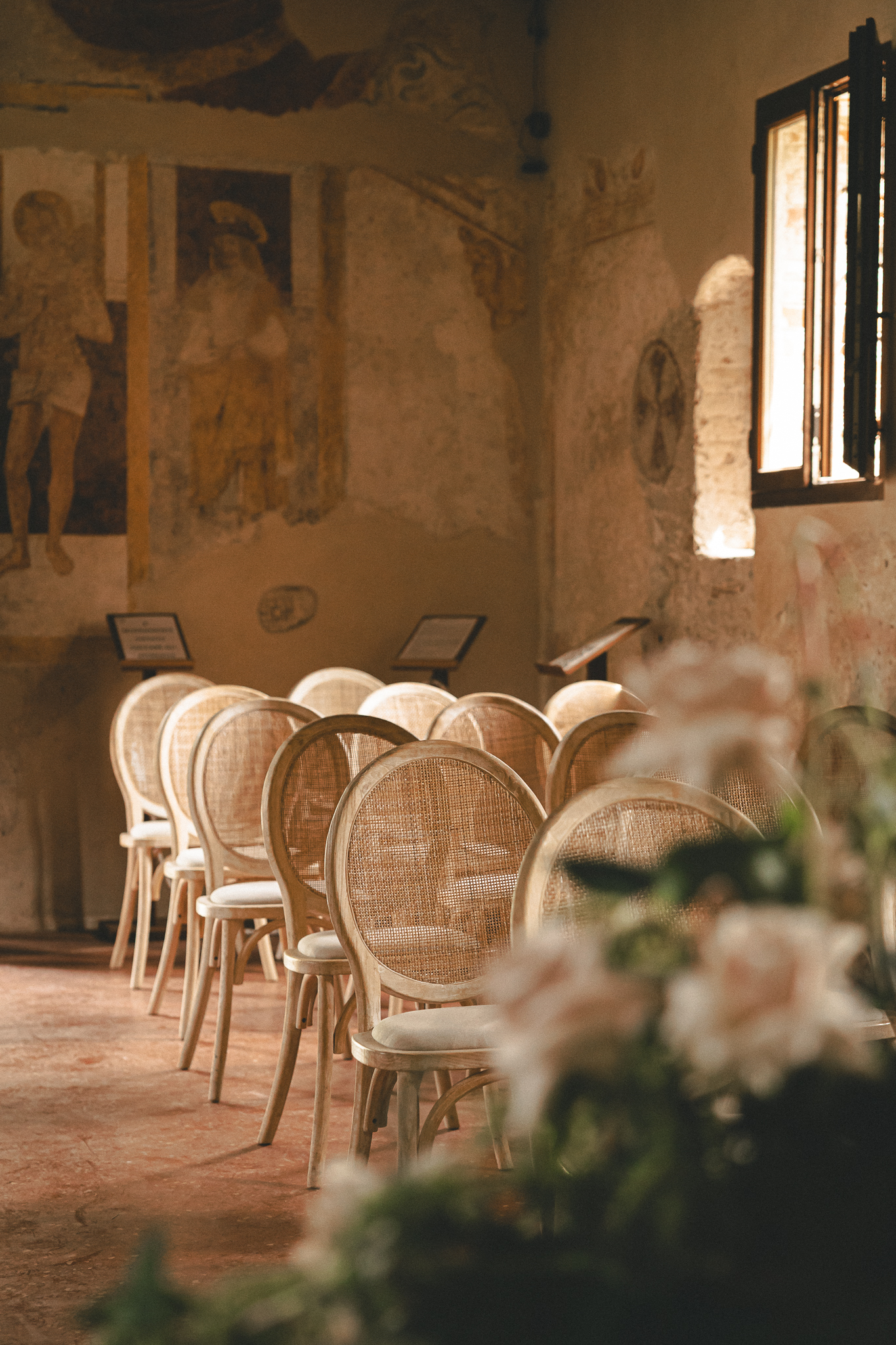 Sedie e fiori nell’oratorio affrescato di Santa Margherita prima della cerimonia