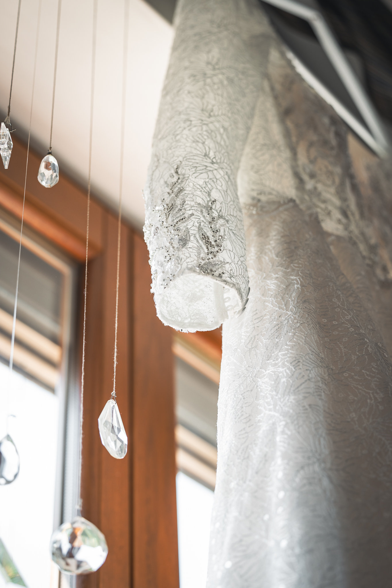 L'abito da sposa appeso alla finestra, il pizzo in controluce