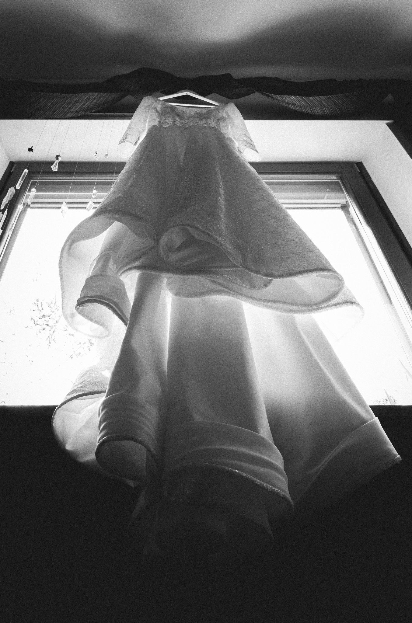 L'abito da sposa in bianco e nero, sospeso contro la luce