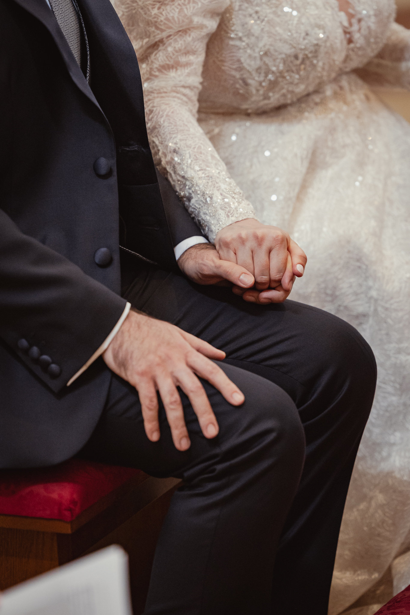 Dettaglio delle mani di Salvatore posate su quelle di Edel durante la funzione