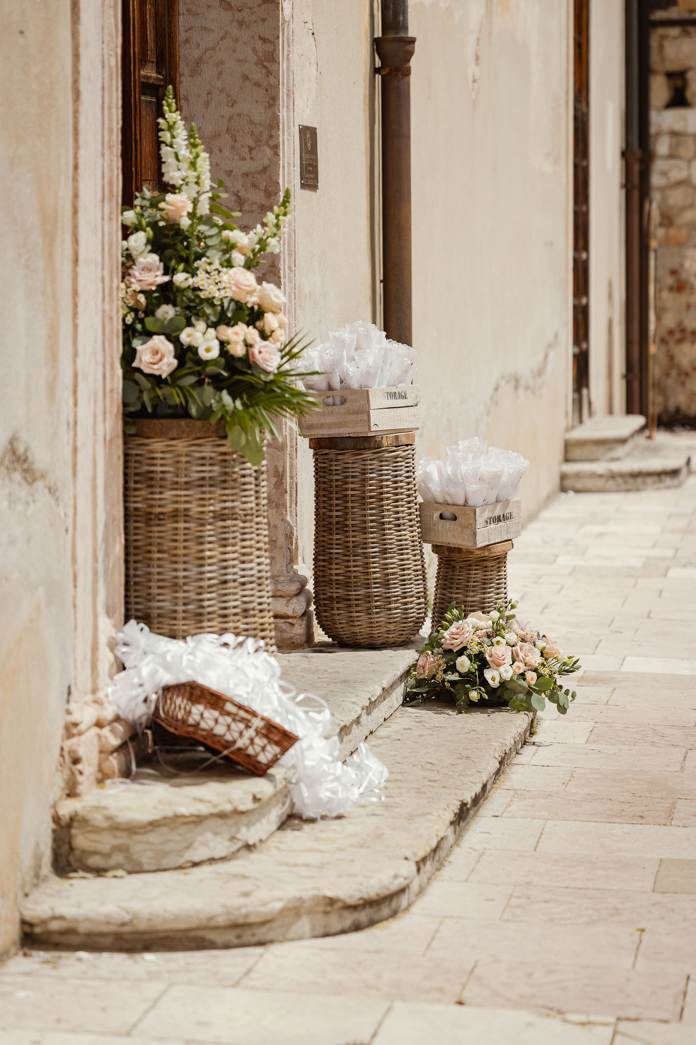 I cesti di fiori bianchi all'ingresso della chiesa