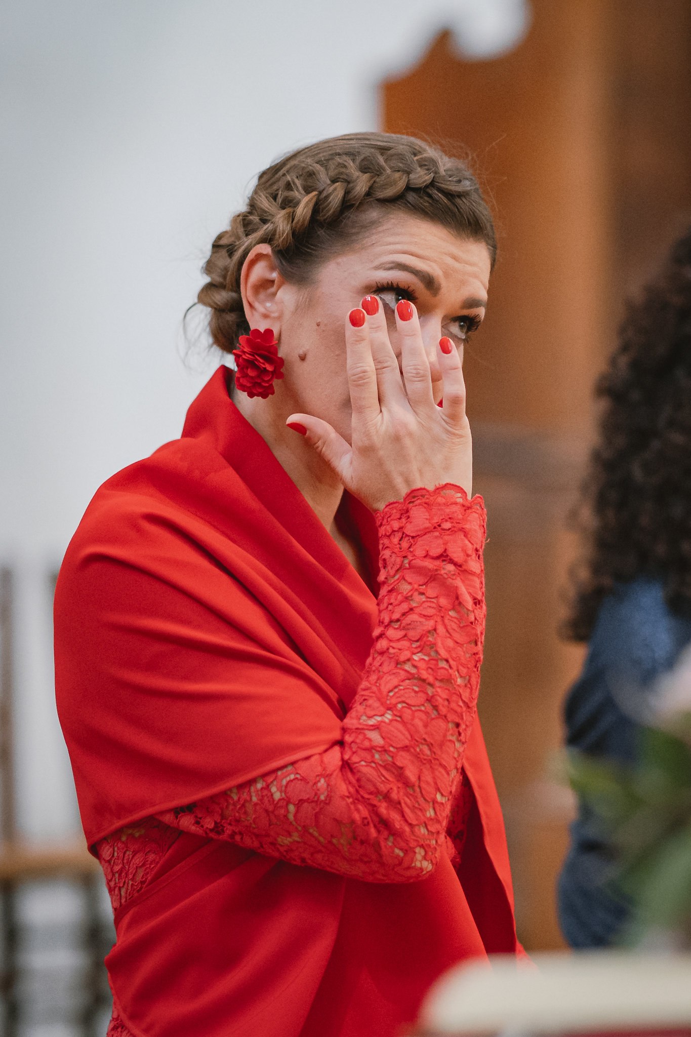 Un'invitata commossa si asciuga le lacrime durante la cerimonia