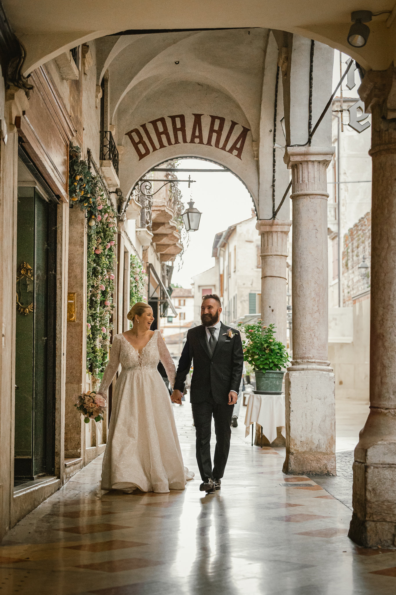 Gli sposi camminano sotto i portici del centro storico