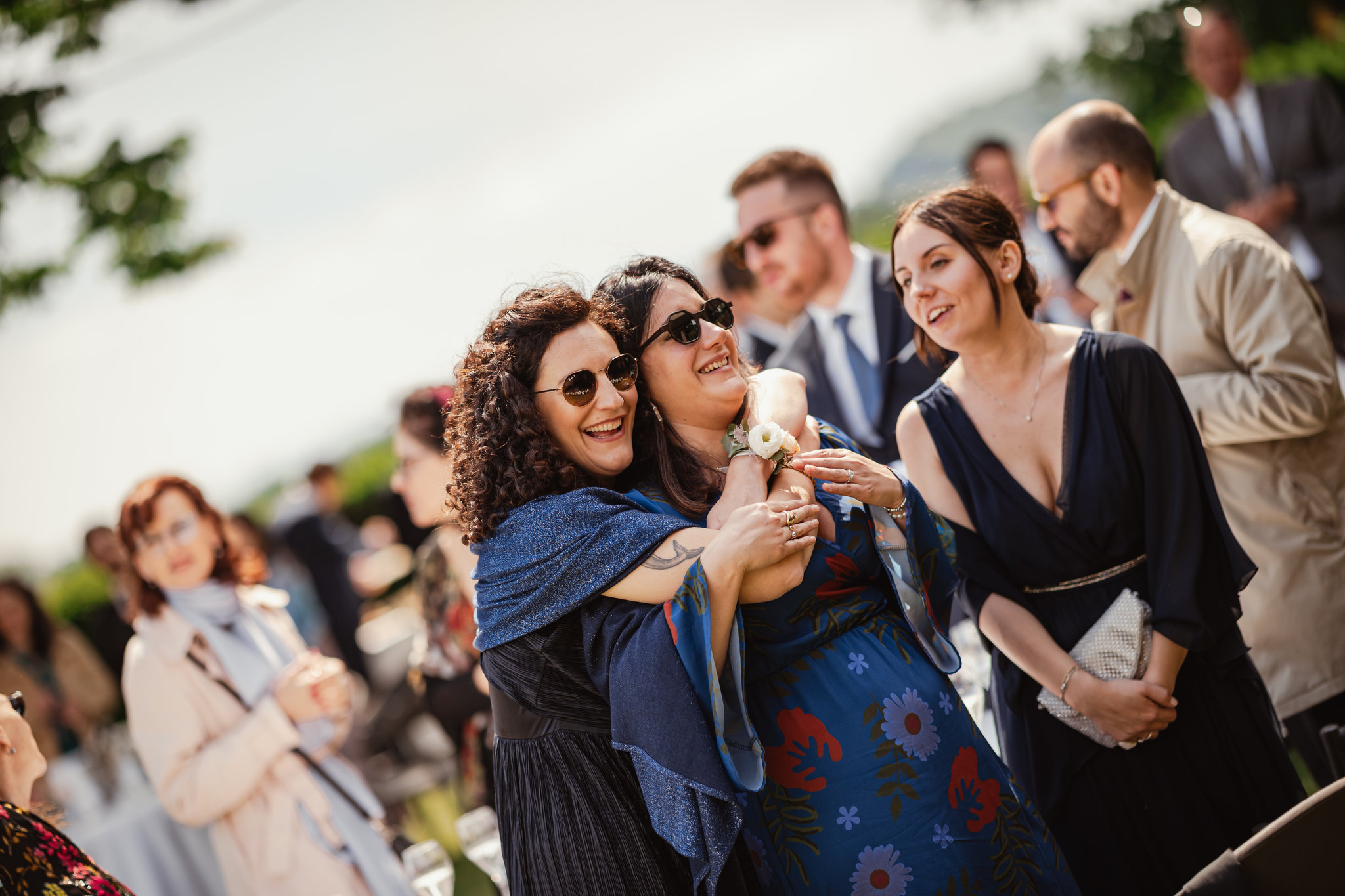 Amiche ridono insieme durante l'aperitivo nel parco della villa
