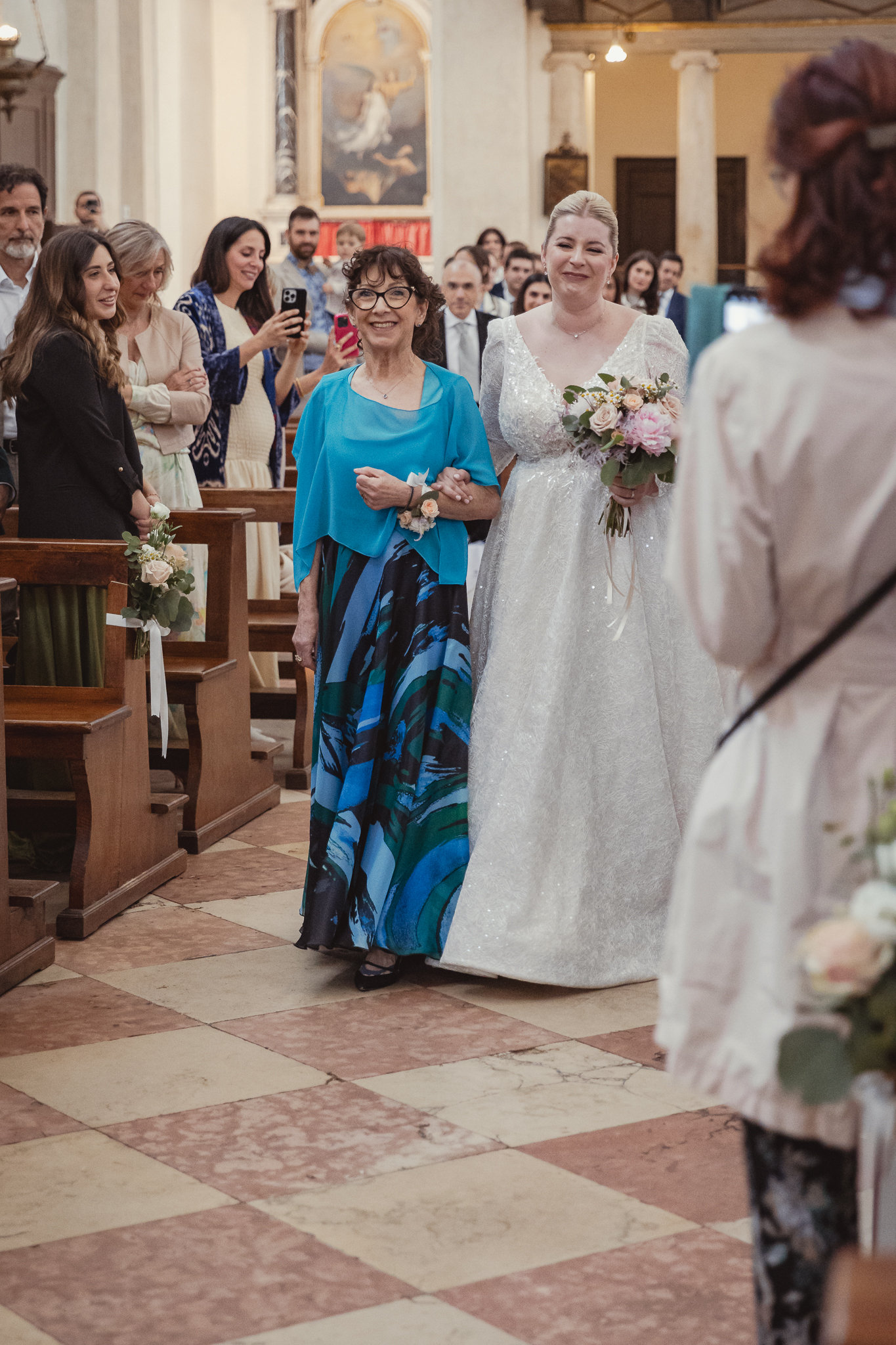 Edel percorre la navata accompagnata dalla mamma verso l'altare