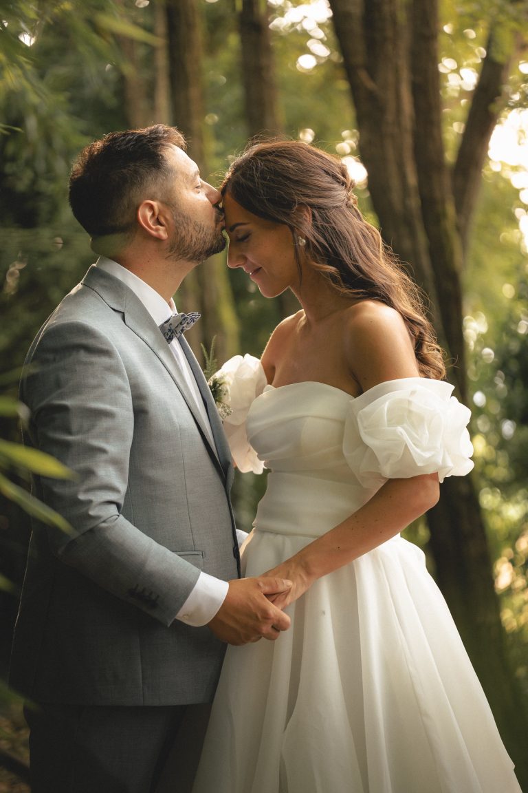 Michele bacia Marta sulla fronte nella luce dorata del bosco